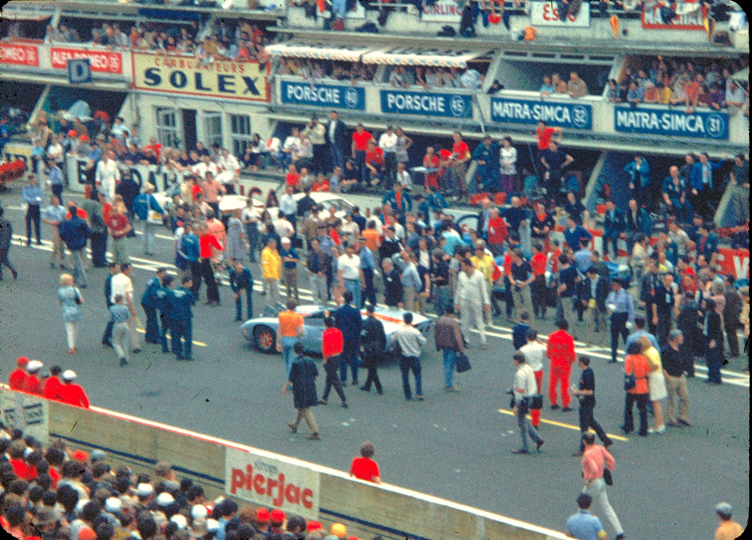 Pit lane scene during filming of Le Mans, 1970, with production crew and racing cars